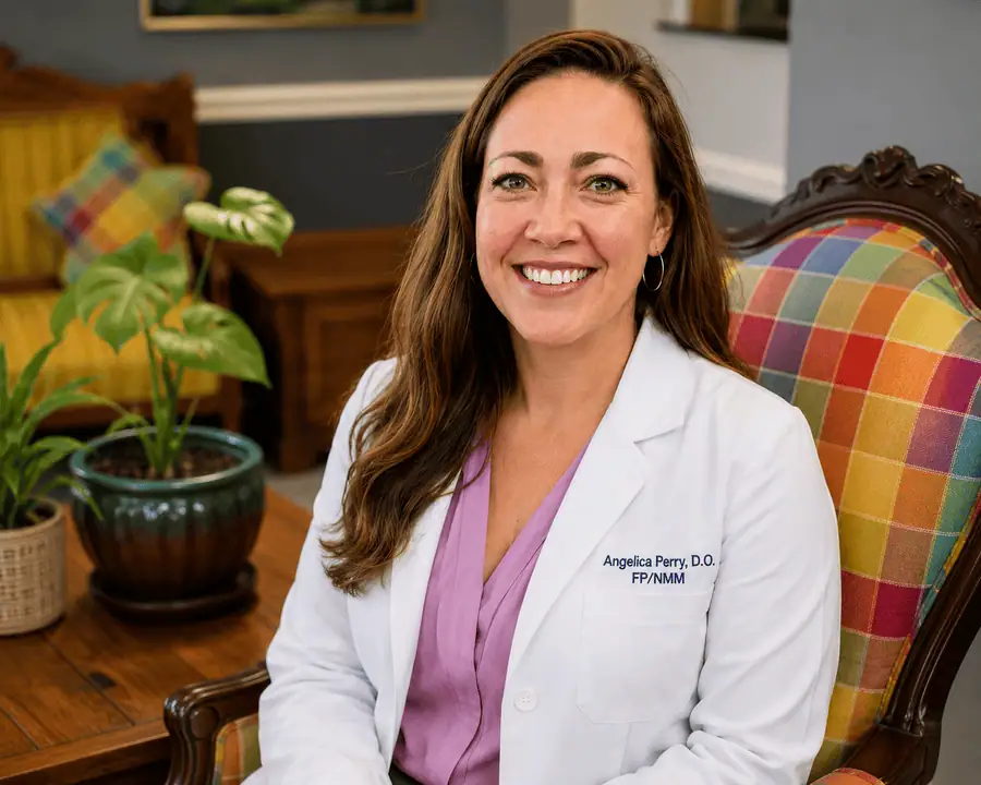 Dr Angelica Perry, D.O., is pictured seated and smiling.