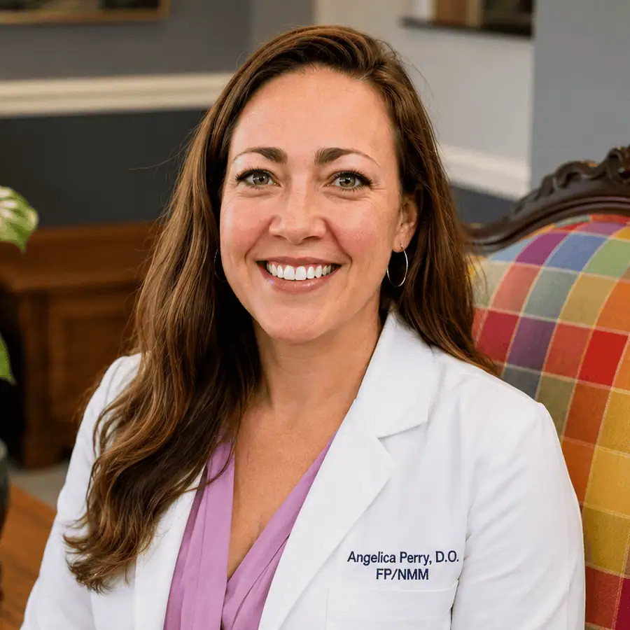 Dr Angelica Perry, D.O., is pictured seated and smiling.